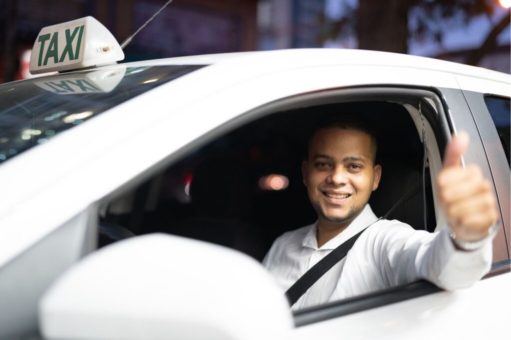 Smiling taxi driver giving a thumbs up